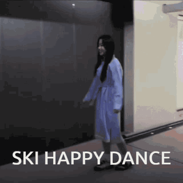 a woman in a blue robe is dancing with the words ski happy dance written below her