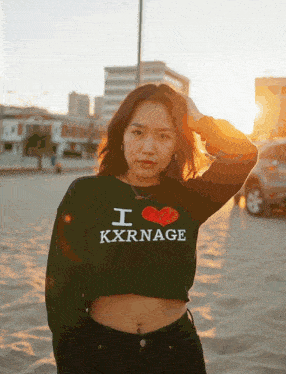 a woman wearing a black sweater that says i love kxrnage