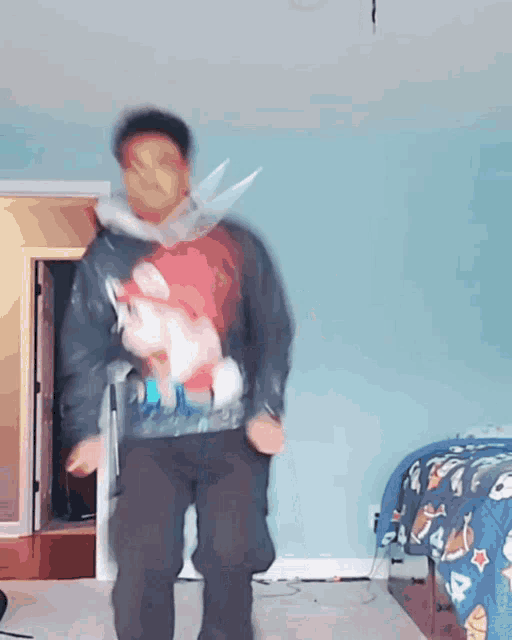 a blurry picture of a man dancing in a room with a bed in the background