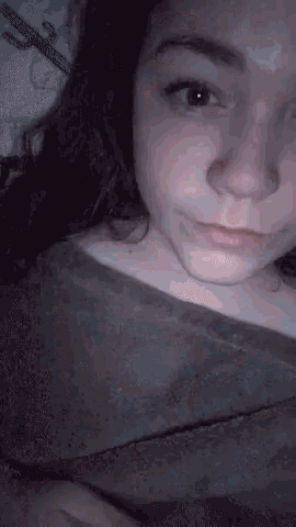 a close up of a woman 's face with a blanket around her .