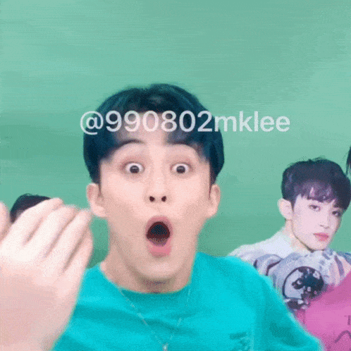 a man with a surprised look on his face is standing in front of a green wall .