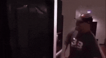 a man in a baseball cap is standing in front of a door .