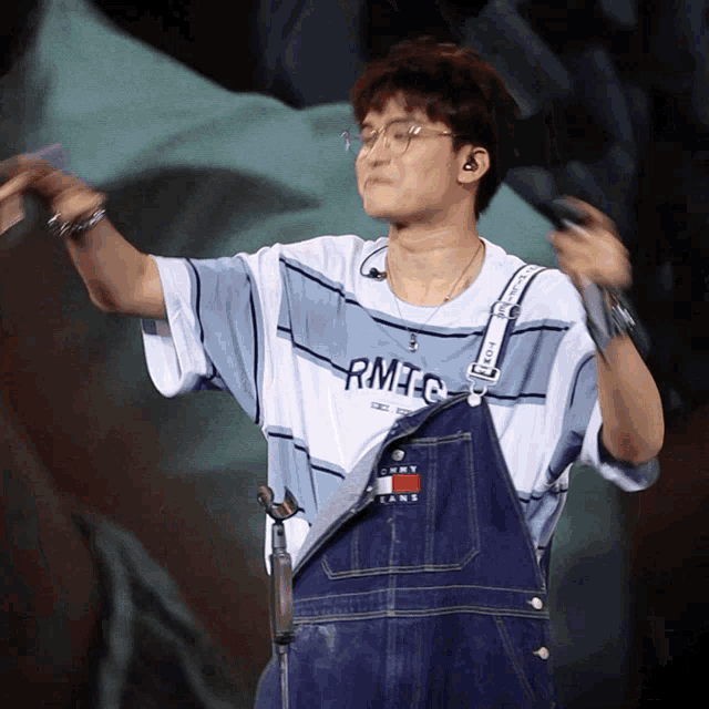 a person wearing overalls and a shirt that says rmtec