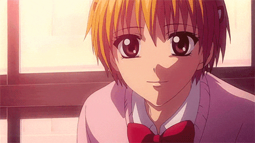 a girl with short blonde hair and a red bow tie