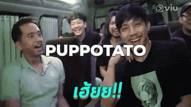a group of men are sitting on a bus and one of them is wearing a shirt that says ' puppetato ' on it