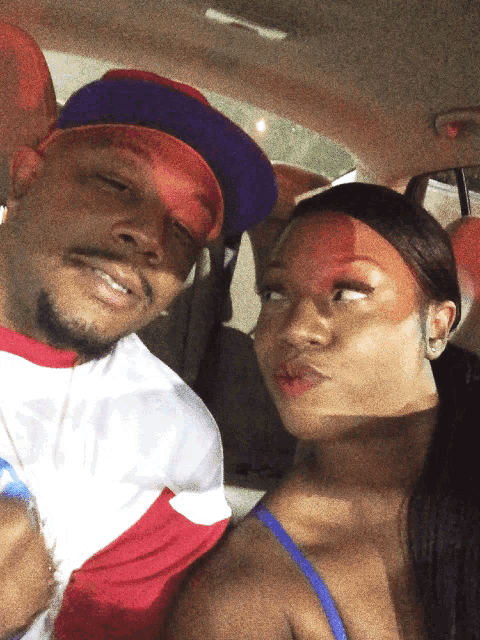 a man and a woman are posing for a picture in the back of a car