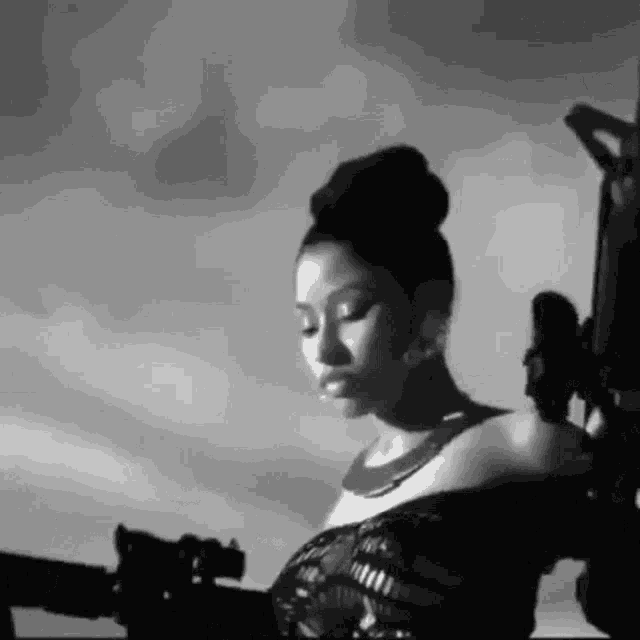 a black and white photo of a woman holding a gun and a microphone .