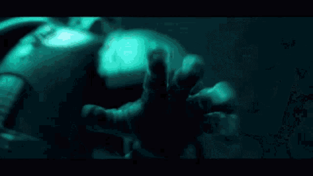 a close up of a person 's face with a helmet on in a dark room