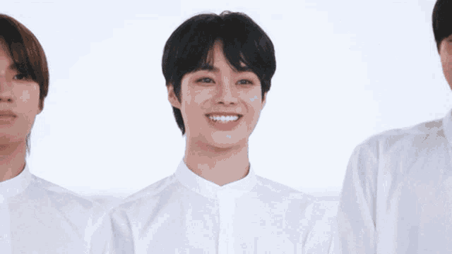 a group of young men wearing white shirts are smiling