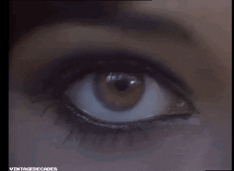 a close up of a woman 's eye with black eye shadow .