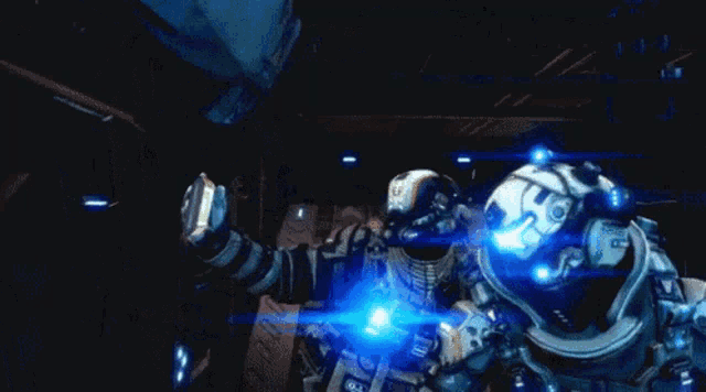 two astronauts are standing next to each other in a dark room and one has the letter s on his chest