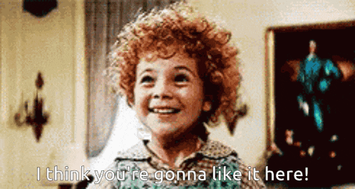 a little girl with curly hair smiles and says i think you 're gonna like it here