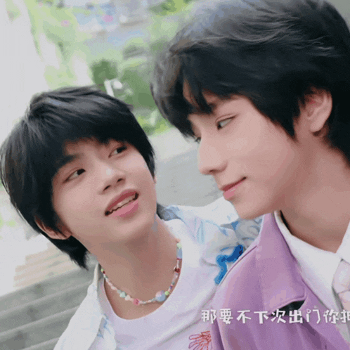 two young boys are looking at each other with chinese writing on the bottom