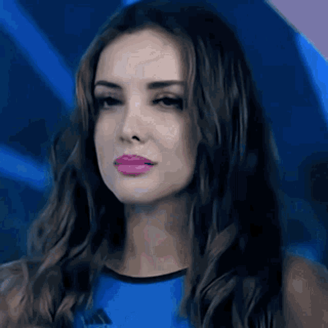 a close up of a woman wearing a blue adidas tank top