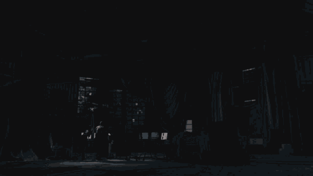 a man and a woman are looking at something in a dark room