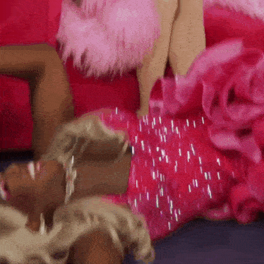 a woman in a pink dress laying on the floor