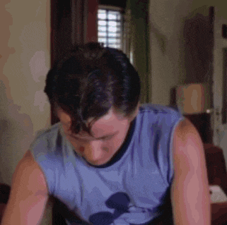 a man wearing a blue shirt with a mickey mouse on it is sweating .