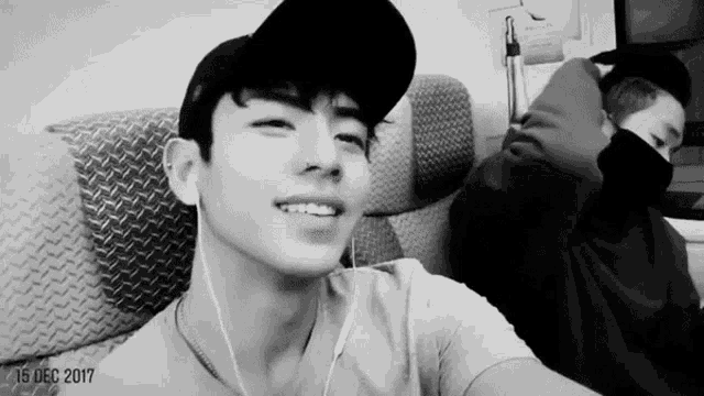 a black and white photo of a man wearing a hat and earbuds