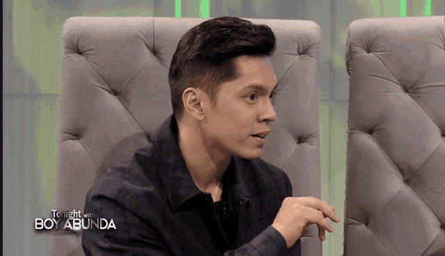 a man is sitting in a chair with the words tonight with boy abunda on the screen