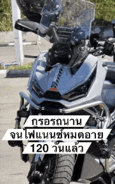 a motorcycle is parked in a parking lot with the words 120 on the bottom right