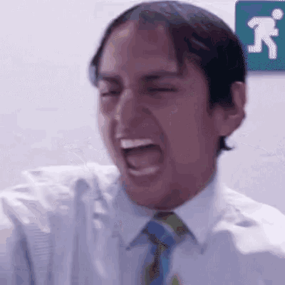 a man in a white shirt and tie is making a funny face in front of a sign that says ' a '