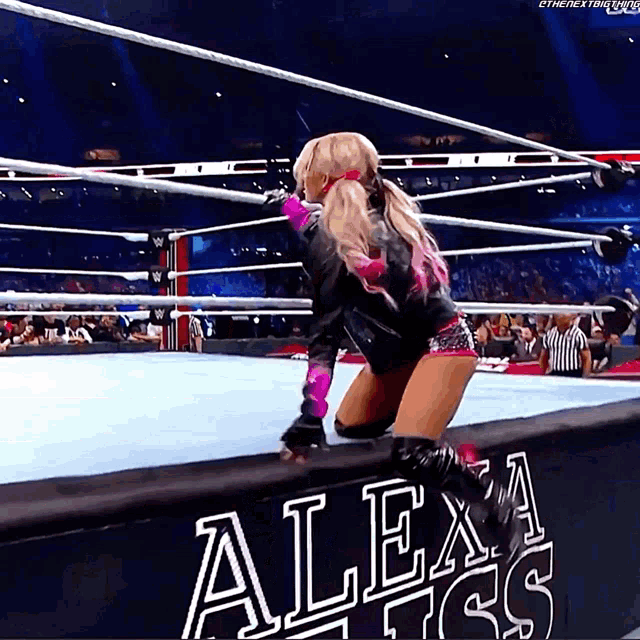 a woman in a wrestling ring with a sign that says alexa