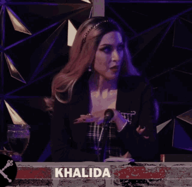 a woman is standing in front of a microphone with the name khalida written on the bottom