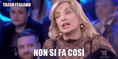 a woman is sitting in front of a crowd and saying non si fa così
