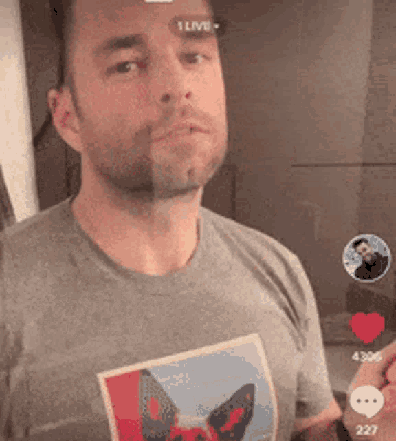 a man wearing a grey t-shirt with a picture of a cat on it