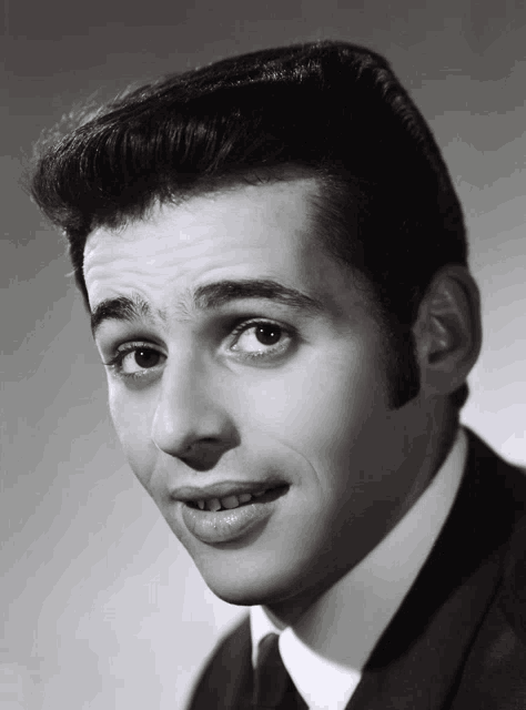 a black and white photo of a young man in a suit
