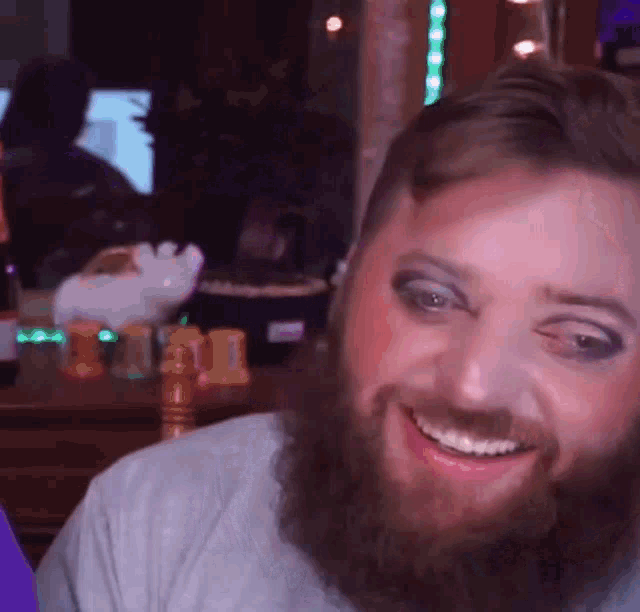 a man with a beard and makeup is smiling