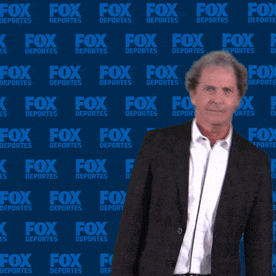 a man is giving a thumbs up in front of a fox deportes wall