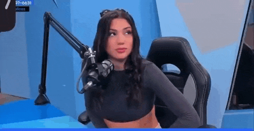 a woman is sitting in a chair in front of a microphone in a room .
