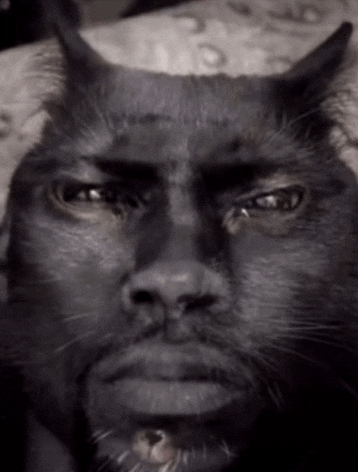 a black and white photo of a cat 's face with horns and a beard