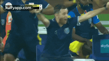 a group of soccer players are celebrating a goal on a field ..