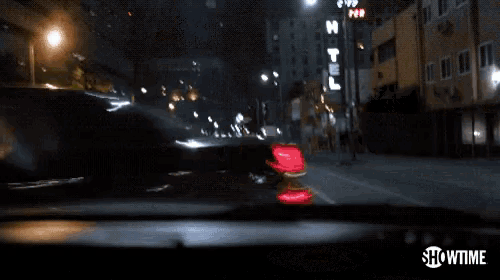 a car is driving down a street with showtime written on the bottom