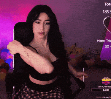 a woman with a tattoo on her arm is sitting in front of a screen that says miami trip on it
