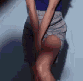 a woman in a blue shirt and gray shorts is holding her legs .