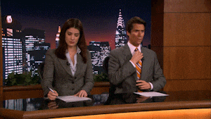 a man and a woman are sitting at a desk in front of a city at night