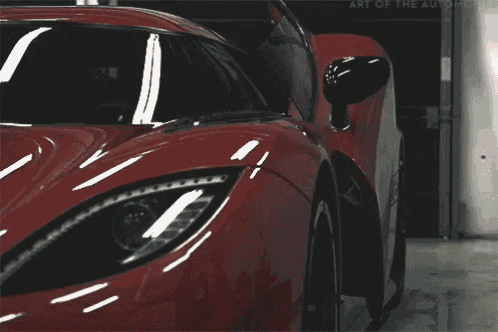 a close up of a red sports car with the word a on the bottom left