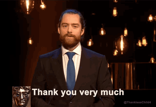 a man in a suit and tie is giving a thank you very much speech