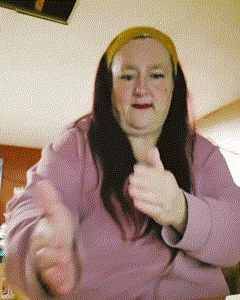 a woman wearing a purple shirt and a yellow headband is giving a thumbs up