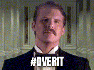 a man in a tuxedo with a mustache is standing in front of a wall and says #overit .