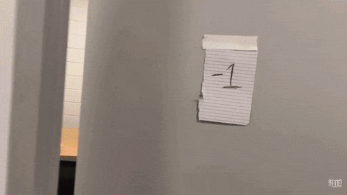a person is sitting at a table with a tissue on it and a gray wall behind them .