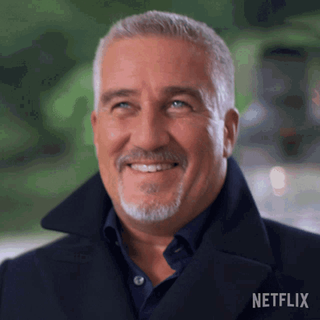 a man with a beard is smiling with a netflix logo in the corner