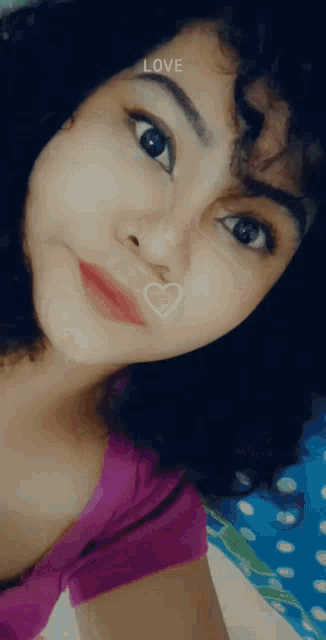 a girl with curly hair is taking a selfie with a heart on her face and the word love above her