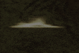 a blurred image of a ufo flying in the dark .