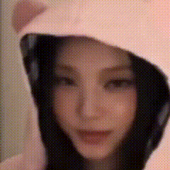a close up of a woman wearing a pink hoodie with headphones .