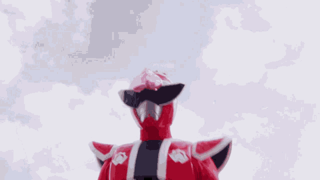 a red and white superhero is holding a fan in his hands