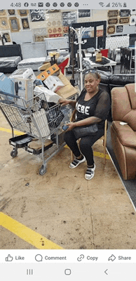 a woman is sitting in a chair next to a shopping cart filled with items